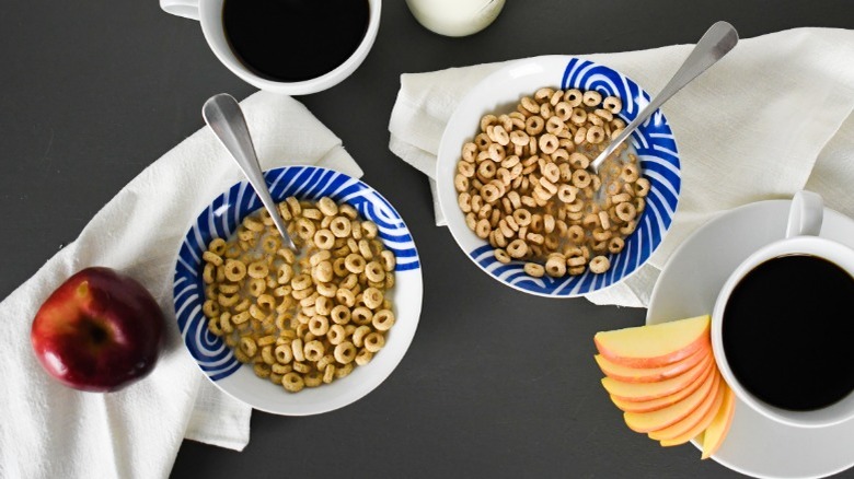 bowls of cheerios and crispy oats cereals at the breakfast table