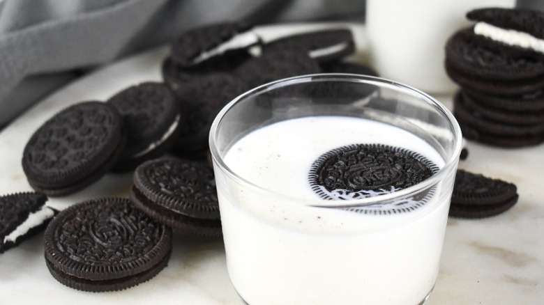 an oreo cookie floating in a glass of milk