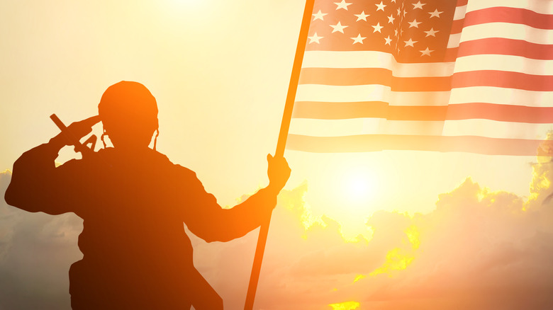 Silhouette of soldier saluting American flag