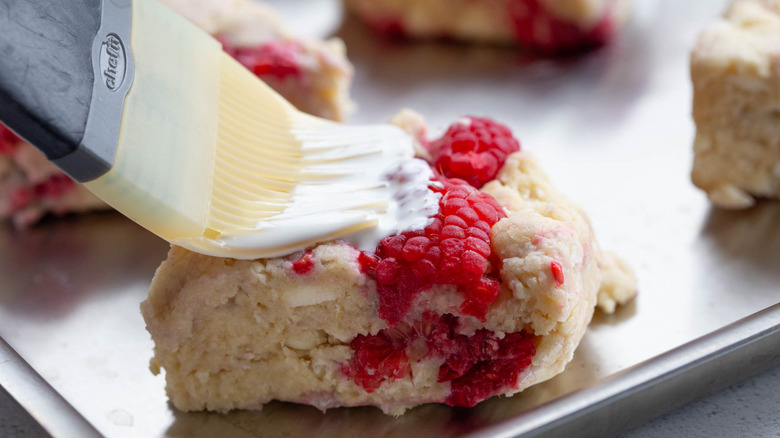 brushing cream on scone top