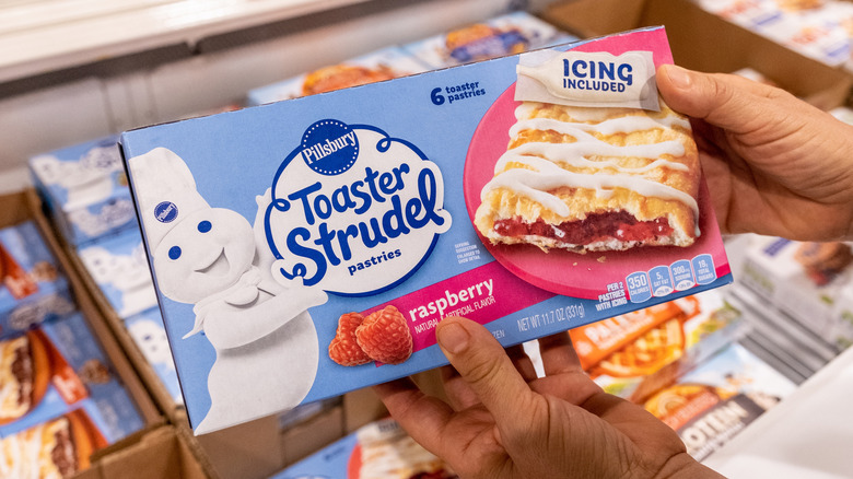 hands holding box of raspberry Toaster Strudel