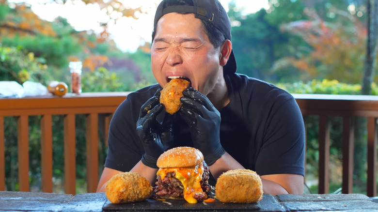 Bayashi eating thick, cheesy burger