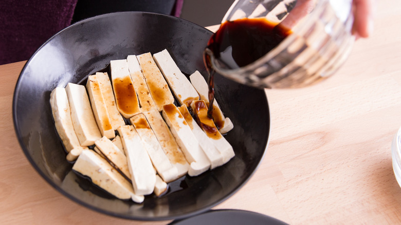 marinade being poured over tofu