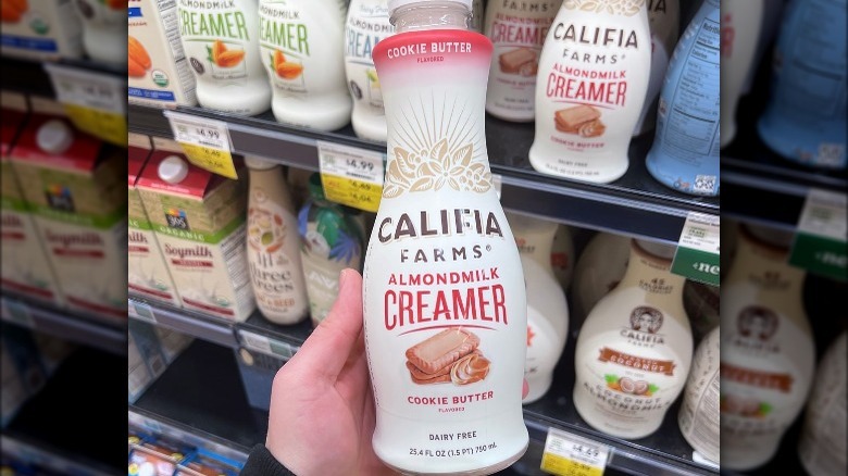 hand holding Califia Farms coffee creamer