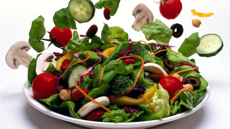 A salad with numerous floating toppings