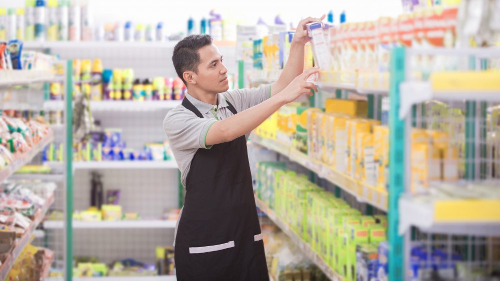 A grocery store worker stocking shelves