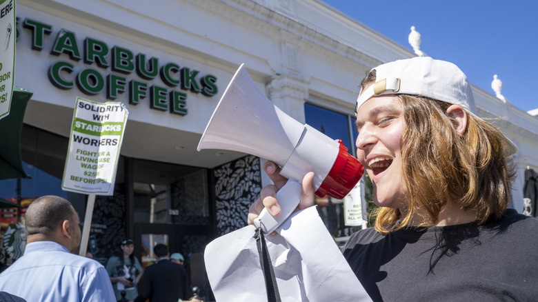 starbucks employee pickets with megaphone