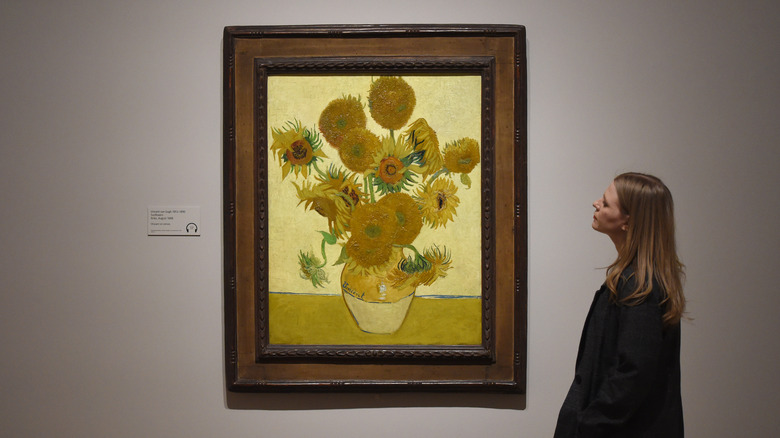 woman looking at sunflowers painting