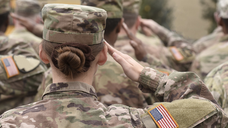 U.S. military service members standing at attention and saluting