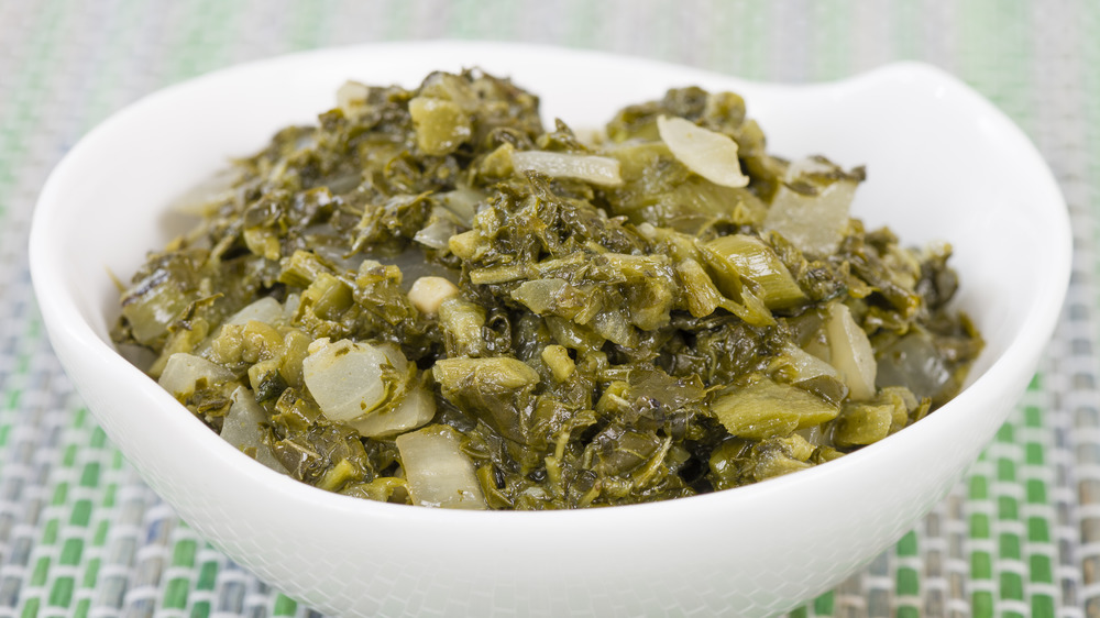 Cooked amaranth greens in a white bowl