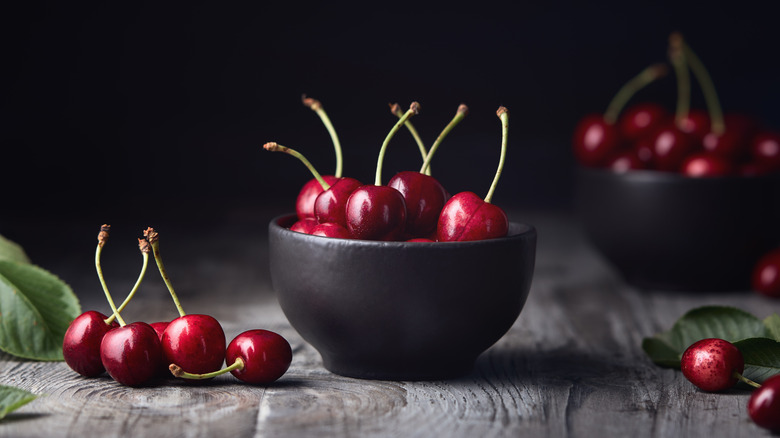 Red cherries in a black bowl