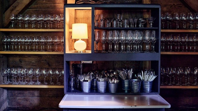 wine glasses and lamp behind bar