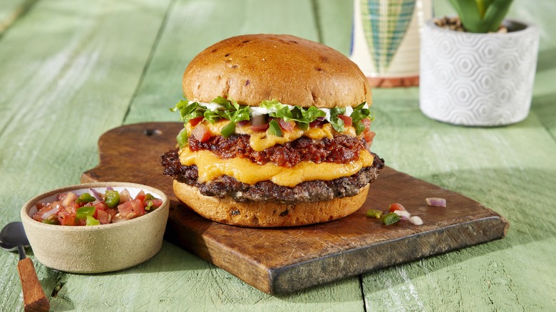 Chorizo cheeseburger on wooden slab