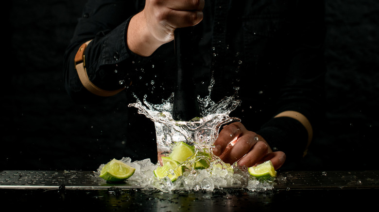 Bartender aggressively muddling a drink 