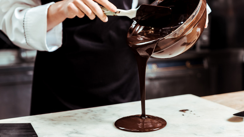 chocolatier pouring chocolate onto marble
