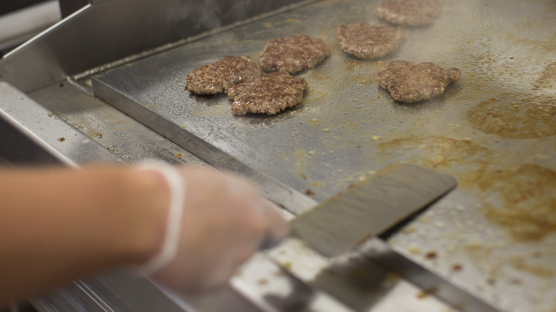 Burger patties cooking on a griddle