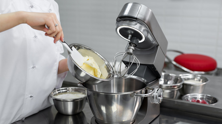 Chef adding soft butter to a stand mixer