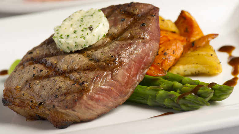 Herb compound butter on steak with asparagus