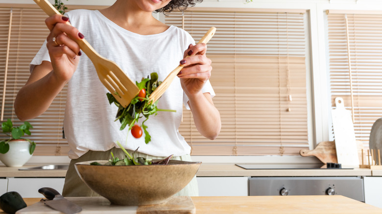 Person mixing a salad