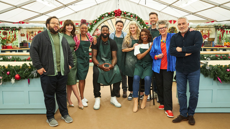 From left to right: Zach Cherry, Casey Wilson, Phoebe Robinson, DeAndre Jordan, Arturo Castro, Heather McMahan, Ego Nwodim, Joel MchHale, Prue Leith, and Paul Hollywood standing together