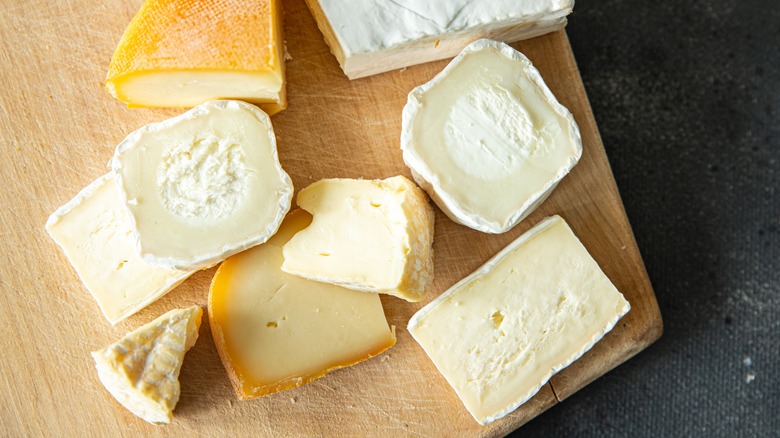 different types of hard and soft cheese on board