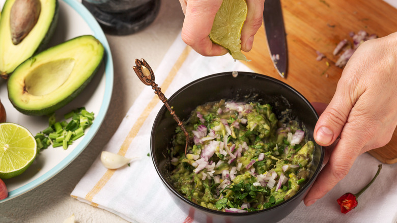 squeezing lime juice on guacamole