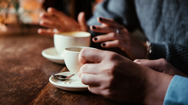 people talking over cups of coffee