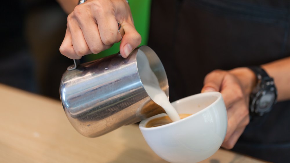 Barista pouring milk