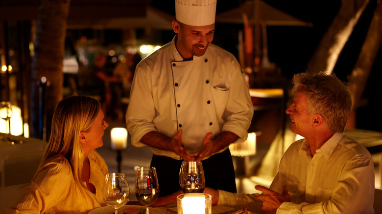 couple speaking with chef