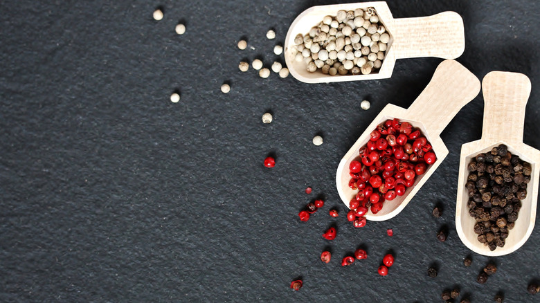 Different types of peppercorns in spoons