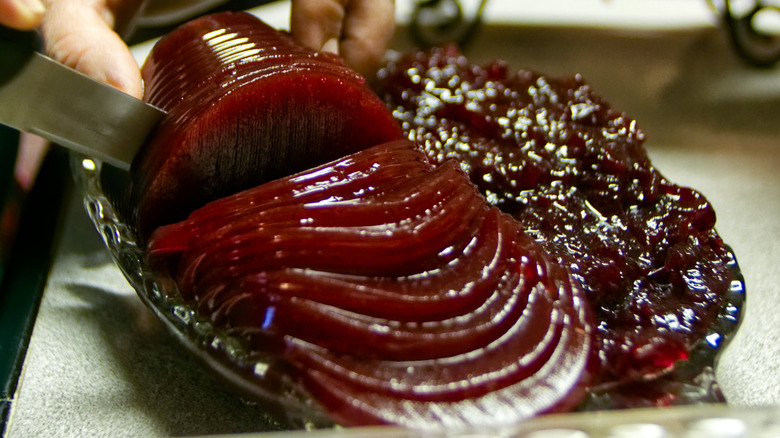 Canned cranberry sauce being sliced