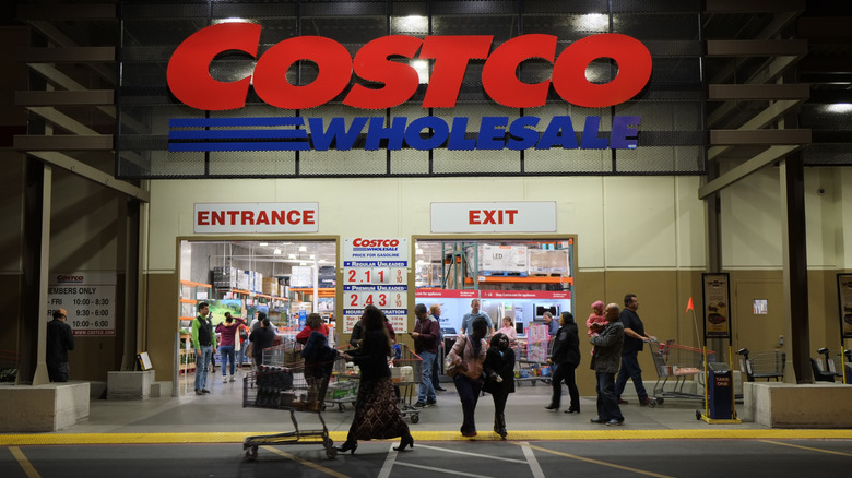 Customers entering and leaving Costco at nighttime