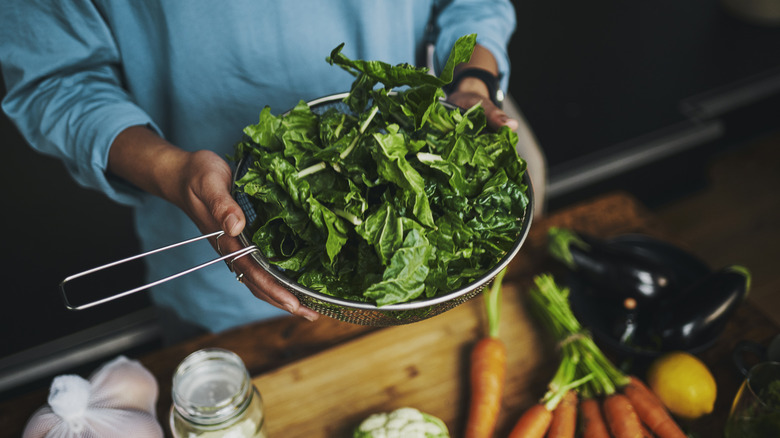 person holding fresh spinach