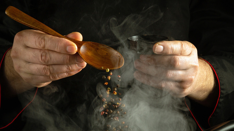 chef adding peppercorns