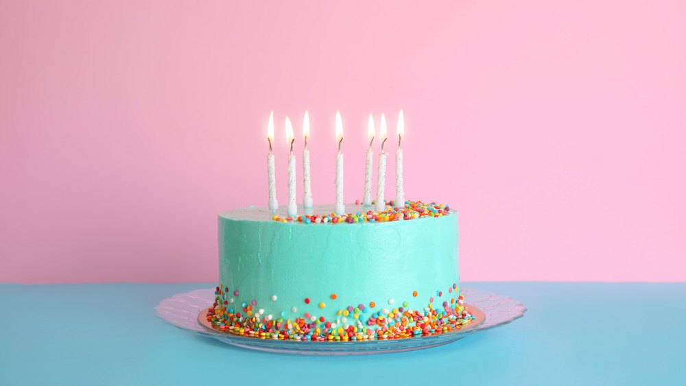 Teal birthday cake on a pink background