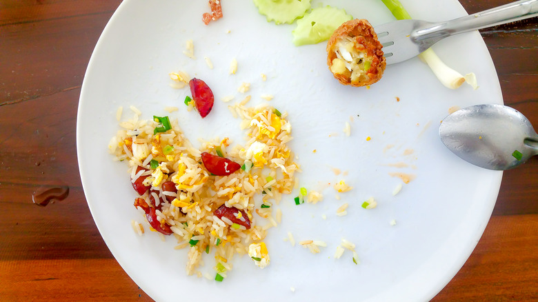 vegetable fried rice on a plate with fork and spoon