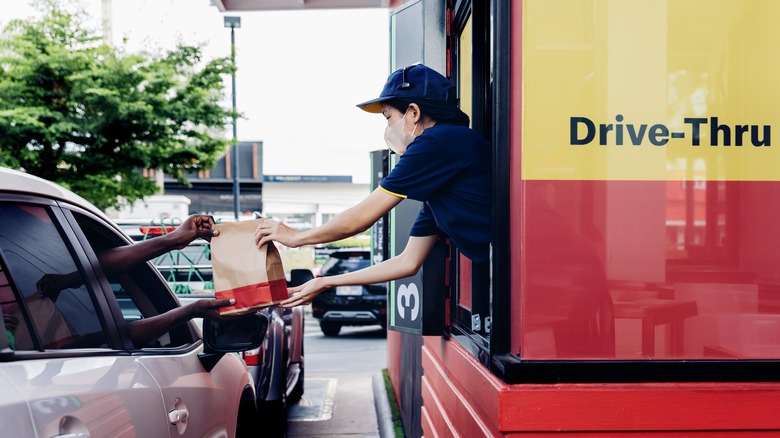 Drive-thru attendant handing customer bag