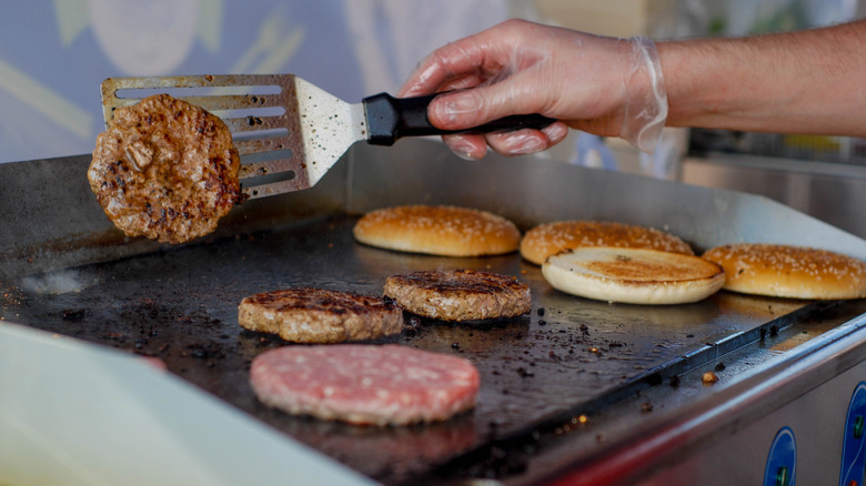 Fast food grill with person flipping burgers