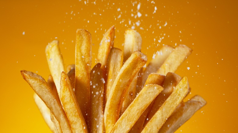 french fries being salted