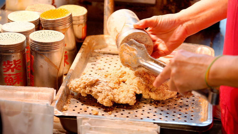 Seasoning a piece of fried chicken