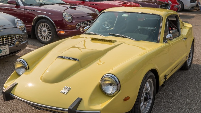 A yellow Saab car on display in lot