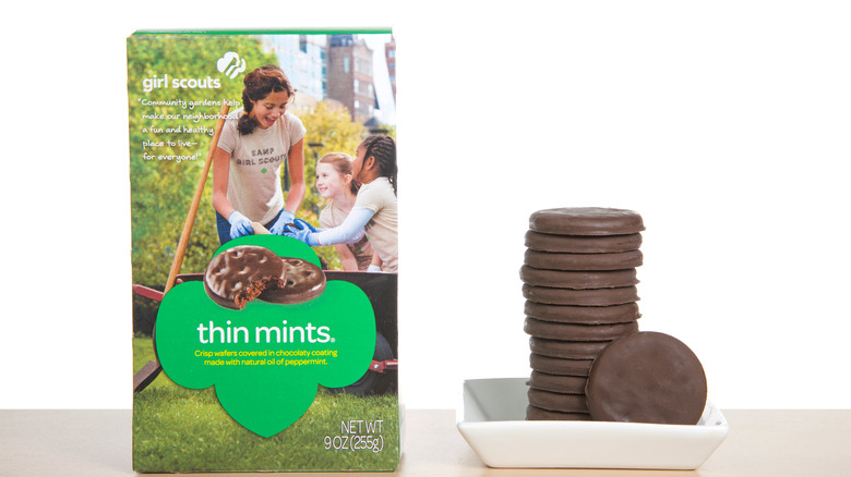 Box of Thin Mints alongside stack of Thin Mints in white dish