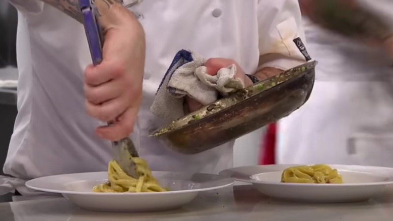 chef swirling pasta on plate