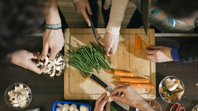 knife cutting green beans with carrots