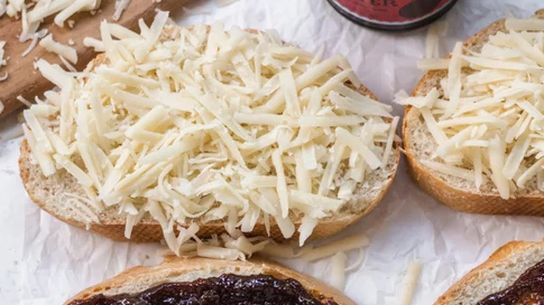 close up of grated cheese on a slice of bread