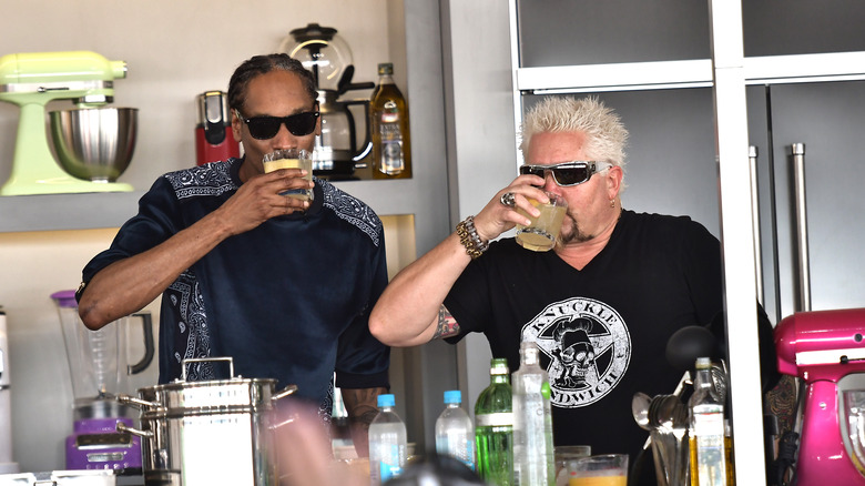 Guy Fieri and Snoop Dogg drinking during cooking show