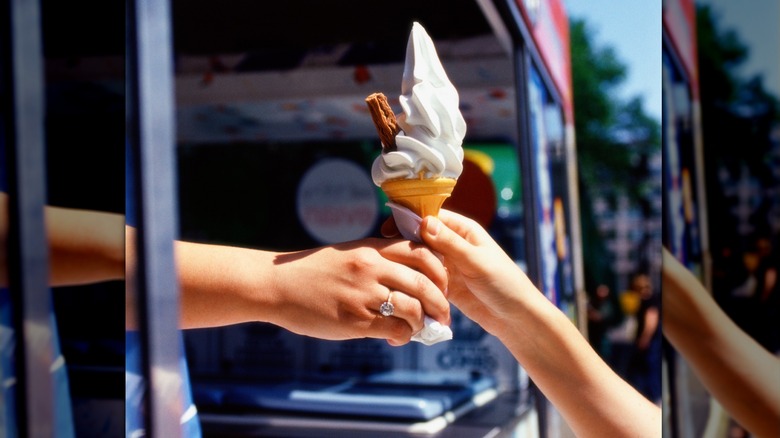 Hand reaching for ice cream from truck