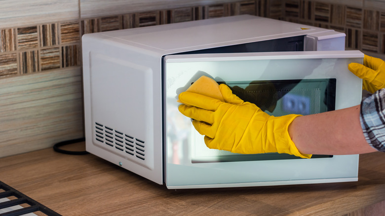 Person cleaning a microwave