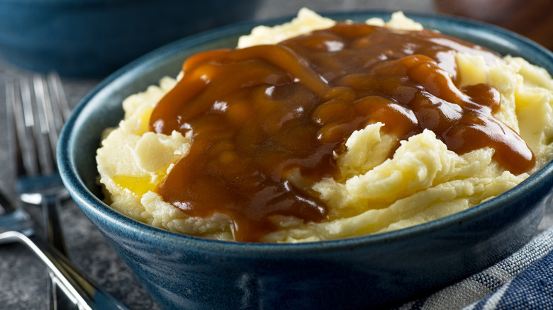 A bowl of mashed potatoes and gravy