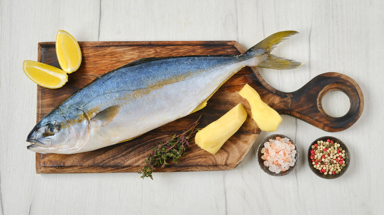 whole Chinook on cutting board with seasoning and lemon